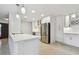 Bright, open kitchen with white cabinets, stainless steel appliances, a center island and terrazzo floors at 4400 Helena Ne St, St Petersburg, FL 33703