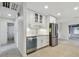 Modern kitchen with white cabinets, stainless steel appliances, and terrazzo flooring at 4400 Helena Ne St, St Petersburg, FL 33703