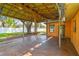 View of a covered patio attached to the house, featuring a wooden beam structure and concrete flooring at 4400 Helena Ne St, St Petersburg, FL 33703
