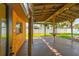 Covered patio with wooden beams, concrete flooring, fan, lights, and a partial kitchen area at 4400 Helena Ne St, St Petersburg, FL 33703