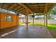Covered patio with wooden framework, lights, outdoor fan, and view of the backyard with white fence at 4400 Helena Ne St, St Petersburg, FL 33703