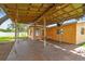 View of a covered patio attached to the house, featuring a wooden beam structure and concrete flooring at 4400 Helena Ne St, St Petersburg, FL 33703