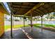 Outdoor patio area with concrete floor, wooden beams, a bar table, and an outdoor fan at 4400 Helena Ne St, St Petersburg, FL 33703