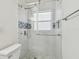 Bright, updated shower with glass doors, marble tiling, and blue decorative tile at 4400 Helena Ne St, St Petersburg, FL 33703