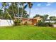 Expansive green lawn and lush landscaping surrounding a cozy single-story home with privacy fence at 4400 Helena Ne St, St Petersburg, FL 33703
