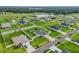 Community aerial view featuring well-maintained lawns, white fences, and a serene pond at 4435 Devinshire Fields Loop, Plant City, FL 33567