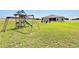 Spacious backyard with a playground, seating area, and ample green space for outdoor activities at 4435 Devinshire Fields Loop, Plant City, FL 33567