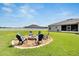 Inviting backyard fire pit with chairs, perfect for outdoor gatherings and relaxation at 4435 Devinshire Fields Loop, Plant City, FL 33567
