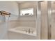 Relaxing bathroom showcasing a soaking tub, neutral tile, and a window for natural light at 4435 Devinshire Fields Loop, Plant City, FL 33567