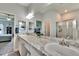 Bright bathroom featuring double sinks, granite countertops, and a glass-enclosed shower at 4435 Devinshire Fields Loop, Plant City, FL 33567