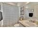 Well-lit bathroom with a striped shower curtain, framed art, and neutral-toned vanity at 4435 Devinshire Fields Loop, Plant City, FL 33567