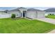 Beautiful home with a lush green lawn, gray exterior, and a two-car garage at 4435 Devinshire Fields Loop, Plant City, FL 33567
