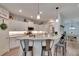 Modern, open kitchen with white cabinetry, a breakfast bar, and stainless steel appliances at 4435 Devinshire Fields Loop, Plant City, FL 33567