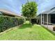 Backyard view showcasing well-maintained landscaping, a gate, and partial home exteriors at 4808 Jewell Ter, Palm Harbor, FL 34685