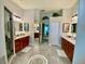 Spacious bathroom with dual sinks, white countertops, wood cabinets, and tile floors at 4808 Jewell Ter, Palm Harbor, FL 34685