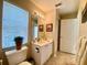 Bright bathroom featuring a single sink vanity and a window with blinds for natural light at 4808 Jewell Ter, Palm Harbor, FL 34685