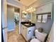 Bathroom with granite countertop, white vanity and adjacent view into an open concept home at 4808 Jewell Ter, Palm Harbor, FL 34685