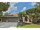 Lovely single-story home with a well-manicured lawn, mature landscaping, and a three-car garage at 4808 Jewell Ter, Palm Harbor, FL 34685