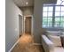 Hallway with tile floor, white couch, and access to bathroom and bedroom at 4808 Jewell Ter, Palm Harbor, FL 34685