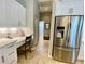 White kitchen featuring a built-in desk, stainless steel refrigerator, and access to the laundry room at 4808 Jewell Ter, Palm Harbor, FL 34685