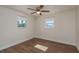 Well-lit bedroom with wood-look flooring, ceiling fan, and windows at 4842 Odyssey Ave, Holiday, FL 34690
