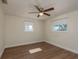 Cozy bedroom with wood-look floors, neutral walls, and large windows for ample natural light at 4842 Odyssey Ave, Holiday, FL 34690
