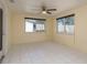 Well-lit living area with neutral walls, tiled floors, and two windows offering ample natural light at 4842 Odyssey Ave, Holiday, FL 34690