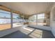 Bright screened porch with white ceiling, gray floor, and views of the home's gravel yard at 4842 Odyssey Ave, Holiday, FL 34690
