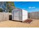 Large, white storage shed in gravel backyard with a small mulch bed at 4842 Odyssey Ave, Holiday, FL 34690