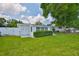 Manicured backyard with lush green grass, well-kept shrubs, and a white fence, providing a serene setting at 513 Fairhope Dr, Apollo Beach, FL 33572