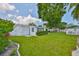 Well-maintained backyard with a green lawn, mature trees, and white fencing, offering a private outdoor space at 513 Fairhope Dr, Apollo Beach, FL 33572