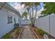 Serene side yard with manicured walkway, mature palms, and lush landscaping at 513 Fairhope Dr, Apollo Beach, FL 33572