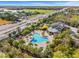 Aerial view showcasing a community pool, clubhouse, lush landscaping, and surrounding area at 5810 Fieldmoor Ct, Palmetto, FL 34221