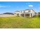 Large backyard with lush green grass, a screened lanai, and a white two-story home in the background at 5810 Fieldmoor Ct, Palmetto, FL 34221