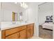Double vanity bathroom leading into cozy bedroom with a bright window at 5810 Fieldmoor Ct, Palmetto, FL 34221