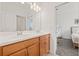 Well-lit bathroom with a double sink vanity, wood cabinets, and a door leading to the bedroom at 5810 Fieldmoor Ct, Palmetto, FL 34221