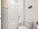 Clean bathroom featuring a bathtub with a shower, tiled walls, and a modern toilet at 5810 Fieldmoor Ct, Palmetto, FL 34221