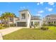 Contemporary two-story home featuring a gray garage door, lush landscaping, and a well-manicured lawn at 5810 Fieldmoor Ct, Palmetto, FL 34221
