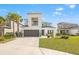 Two story home featuring manicured lawn, elegant balcony, two-car garage, and mature palm trees at 5810 Fieldmoor Ct, Palmetto, FL 34221