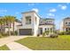 Contemporary two-story home with a gray garage door, lush landscaping, and a well-manicured lawn at 5810 Fieldmoor Ct, Palmetto, FL 34221