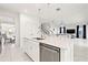 Open concept kitchen with white cabinets and island, and stainless steel appliances, adjacent to the dining and living areas at 5810 Fieldmoor Ct, Palmetto, FL 34221