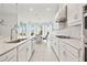 Well-lit kitchen with stainless steel appliances, white cabinets, breakfast nook and stone tile backsplash at 5810 Fieldmoor Ct, Palmetto, FL 34221
