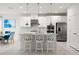 Bright kitchen boasts stainless appliances, quartz countertops, a center island with bar seating, and custom cabinets at 5810 Fieldmoor Ct, Palmetto, FL 34221