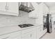 Modern kitchen with white cabinets, gas cooktop, stainless steel appliances, and stylish stone tile backsplash at 5810 Fieldmoor Ct, Palmetto, FL 34221