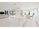 Spacious kitchen island with stainless steel sink, white cabinets, and view to the living room at 5810 Fieldmoor Ct, Palmetto, FL 34221