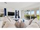 Living room with comfy sectional couch and large windows overlooking outdoor living space at 5810 Fieldmoor Ct, Palmetto, FL 34221