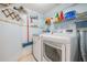 Laundry room equipped with modern washer, dryer, shelves, and cleaning tools at 6322 Palma Del Mar S Blvd # 1107, St Petersburg, FL 33715
