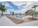 Community pool featuring tiki umbrellas, multiple lounge chairs, and views of the bay at 6322 Palma Del Mar S Blvd # 1107, St Petersburg, FL 33715