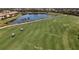 Well-manicured golf course showcasing a pond, golf carts, and lush green fairways within the community at 6715 Grand Estuary Trl # 203, Bradenton, FL 34212