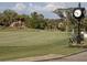 Community golf course view with a vintage clock on a post, manicured greens, and lush landscaping at 6715 Grand Estuary Trl # 203, Bradenton, FL 34212